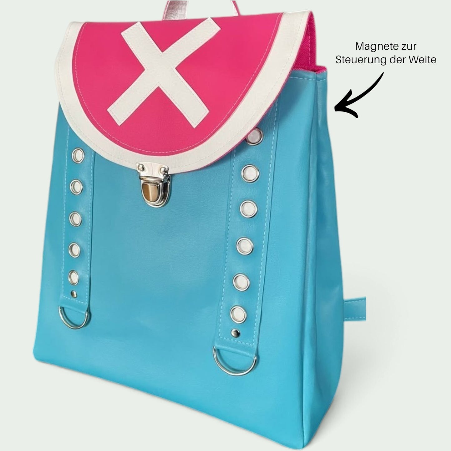 Schneckenschmiede Rucksack aus Kunstleder in Blau und Pink mit weißem Kreuz-Motiv und dekorativen Metallösen.