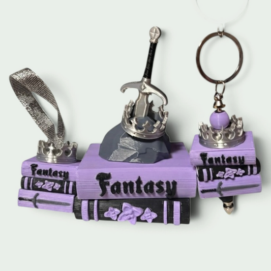 Verleihe deinem Bücherregal, deinem Schlüsselbund oder deinem Weihnachtsbaum den perfekten Fantasy-Vibe! Dieses liebevoll gestaltete "Fantasy" Book Pile mit Krone, Schwert- und Stein-Details ist ein absoluter Hingucker für alle Buchliebhaber.
