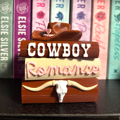 Verleihe deinem Bücherregal, deinem Schlüsselbund oder deinem Weihnachtsbaum den perfekten Cowboy Romance-Vibe! Dieses liebevoll gestaltete "Cowboy Romance" Book Pile ist ein absoluter Hingucker für alle Buchliebhaber.