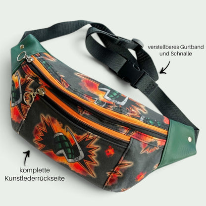 Schneckenschmiede Bauchtasche mit Anime-Print, orangefarbenen Reißverschlüssen, grünem Kunstleder und verstellbarem Gurt.