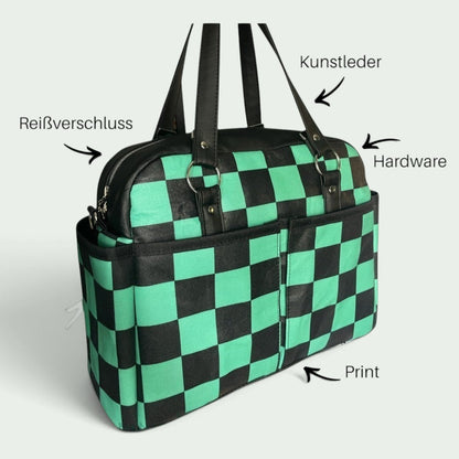 Schneckenschmiede Belle Baby Windeltasche mit grün-schwarzem Karomuster, Kunstleder-Details und Reißverschluss.