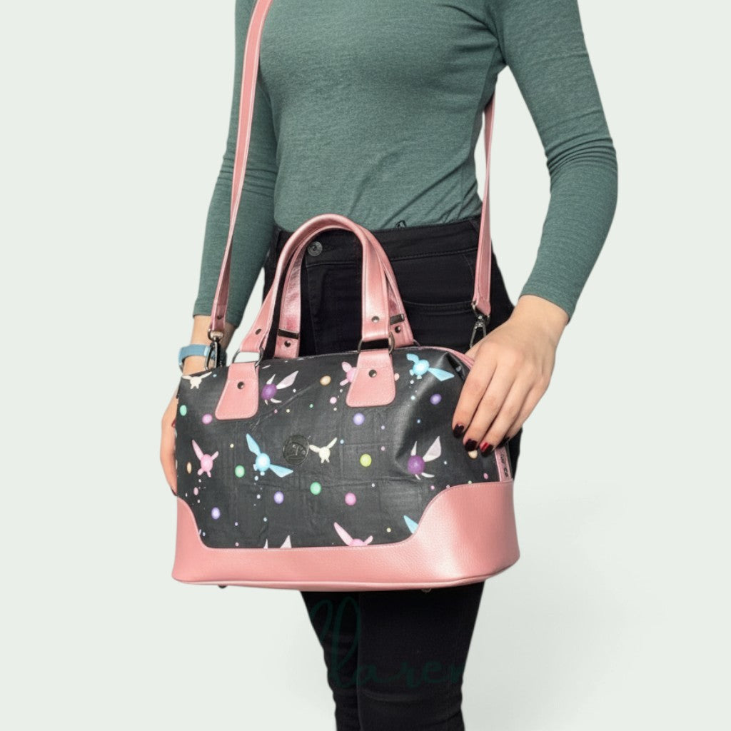 Schneckenschmiede Brooklyn Umhängetasche mit schwarzem Schmetterlings-Print, rosa Kunstleder-Akzenten und Tragegurt.