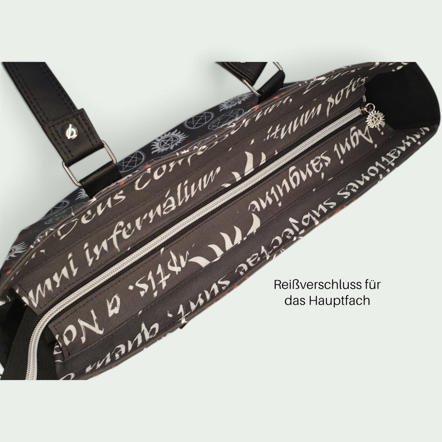 Schneckenschmiede Handtasche Divina mit schwarzem Stoff, weißem lateinischem Schrift-Print und sicherem Reißverschluss