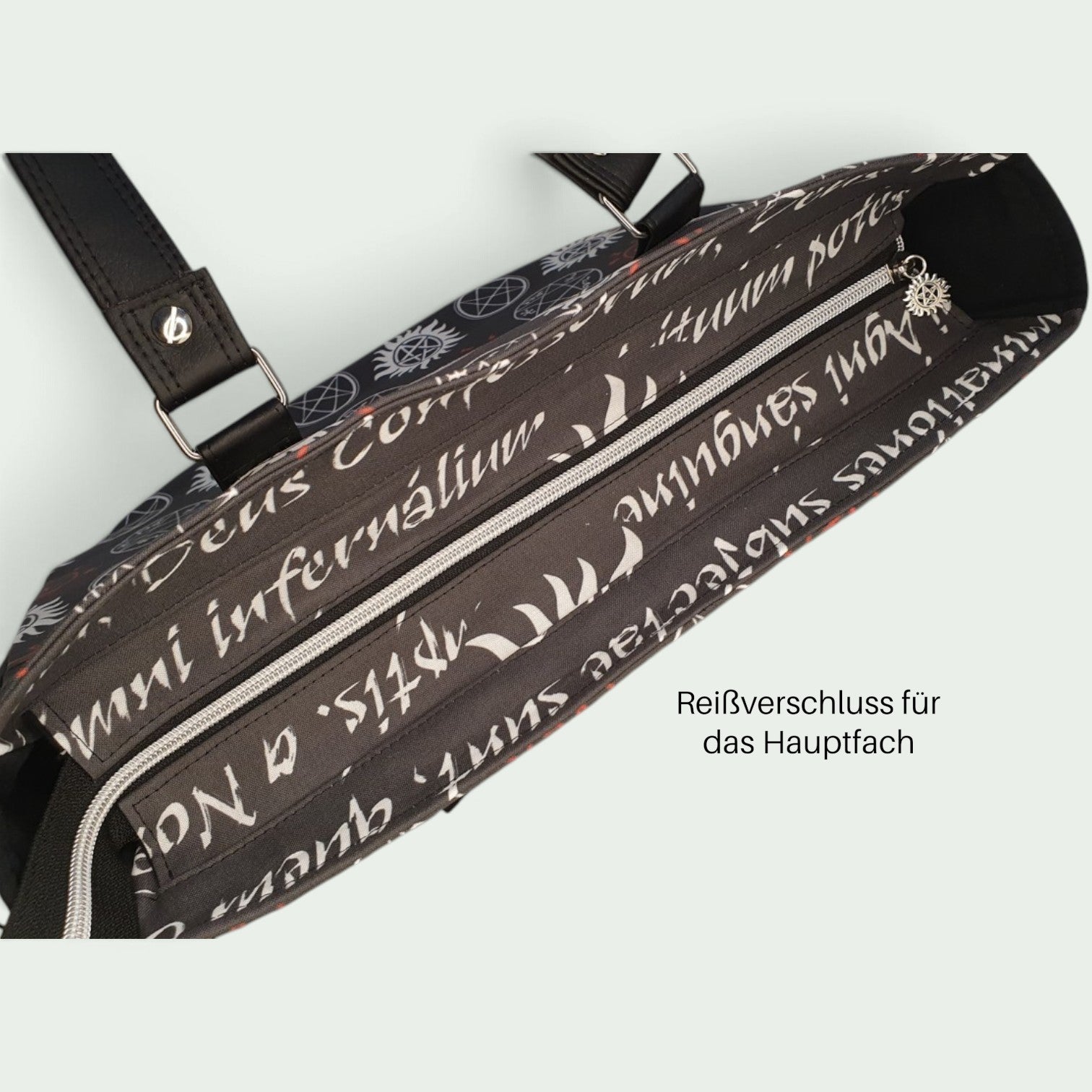Schneckenschmiede Handtasche Divina mit schwarzem Stoff, weißem lateinischem Schrift-Print und sicherem Reißverschluss