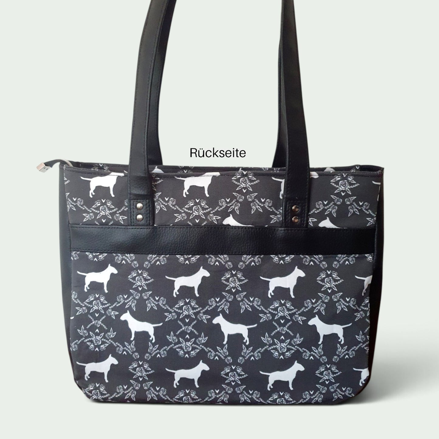 Schneckenschmiede Handtasche Divina mit schwarz-weißem Hundemuster, Kunstleder-Details und zwei Fronttaschen.