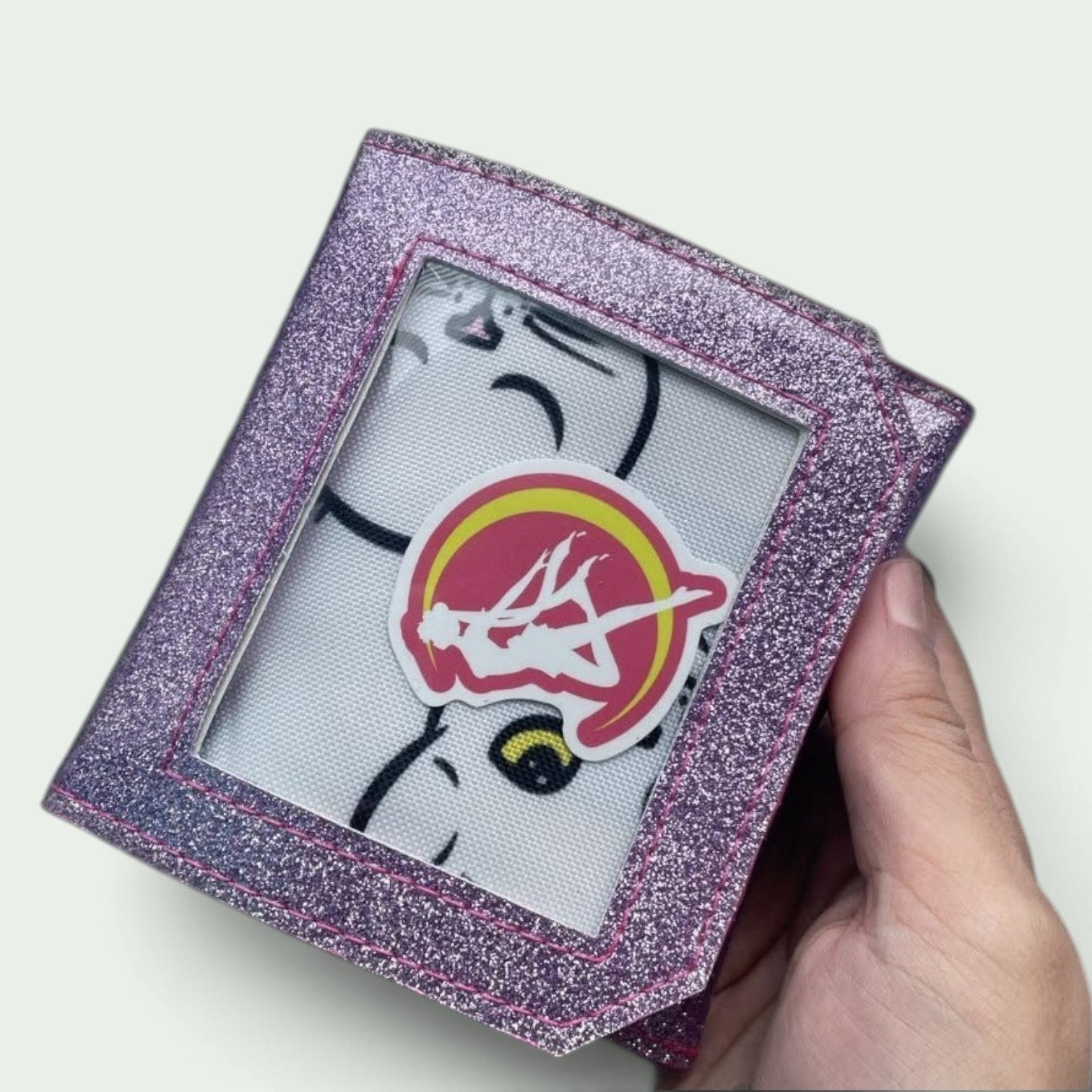 Schneckenschmiede Mini Ita Portemonnaie aus lila Glitzer-Kunstleder mit Sichtfenster für Pins und Sticker