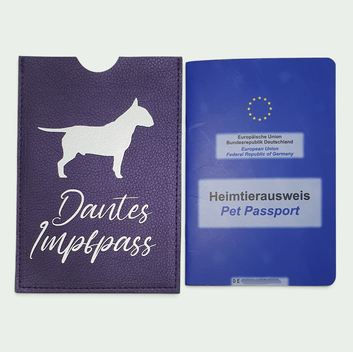 Schneckenschmiede lila Kunstleder Impfpasshülle mit weißem Bullterrier-Motiv und Schriftzug neben EU-Heimtierausweis