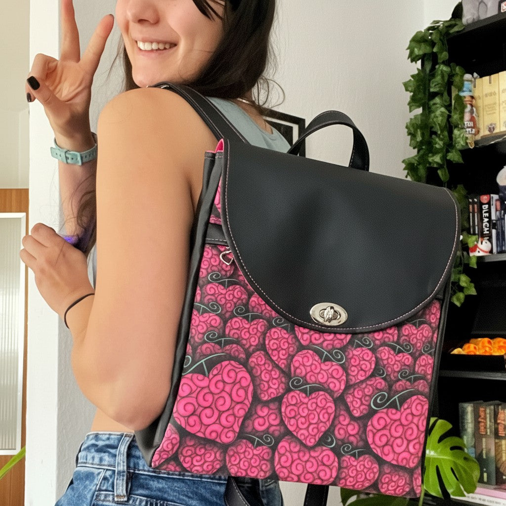 Schneckenschmiede Meraki Rucksack mit pinkem Herzmuster und schwarzem Kunstleder, getragen von einer jungen Frau.