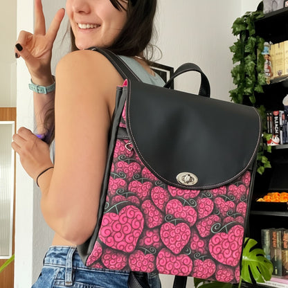Schneckenschmiede Meraki Rucksack mit pinkem Herzmuster und schwarzem Kunstleder, getragen von einer jungen Frau.