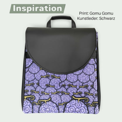 Schneckenschmiede Meraki Rucksack mit lila Gomu Gomu Print und schwarzem Kunstleder, runde Klappe, Vorderansicht