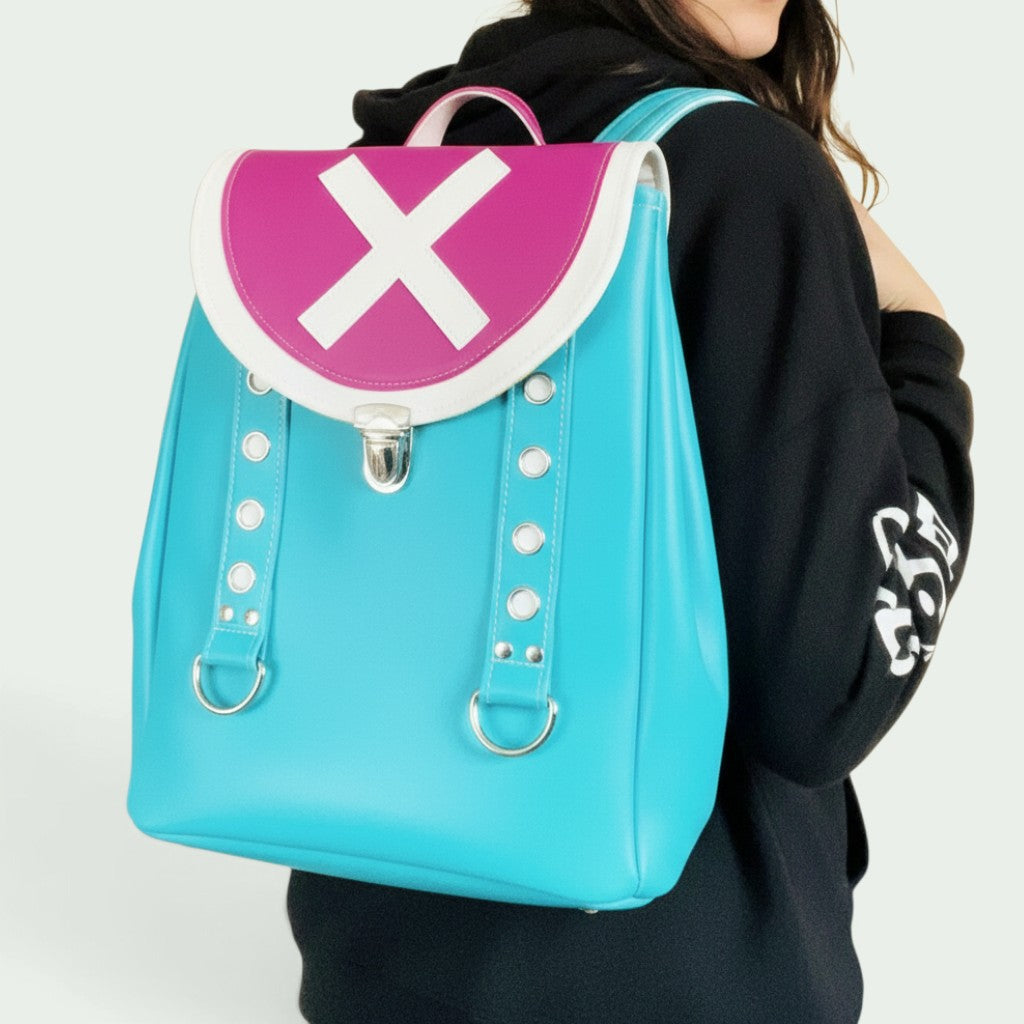 Schneckenschmiede Rucksack aus Kunstleder in Türkis und Pink mit weißem Kreuz-Motiv auf der Klappe
