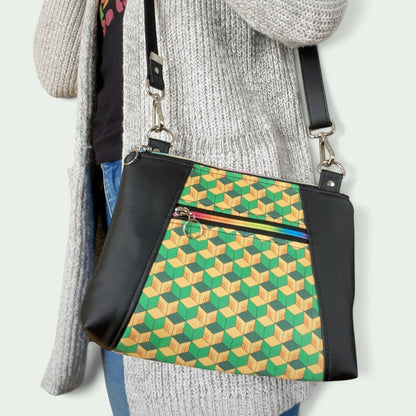 Schneckenschmiede Umhängetasche Sunshine mit geometrischem Muster, schwarzen Kunstleder-Akzenten und Regenbogen-Reißverschluss.