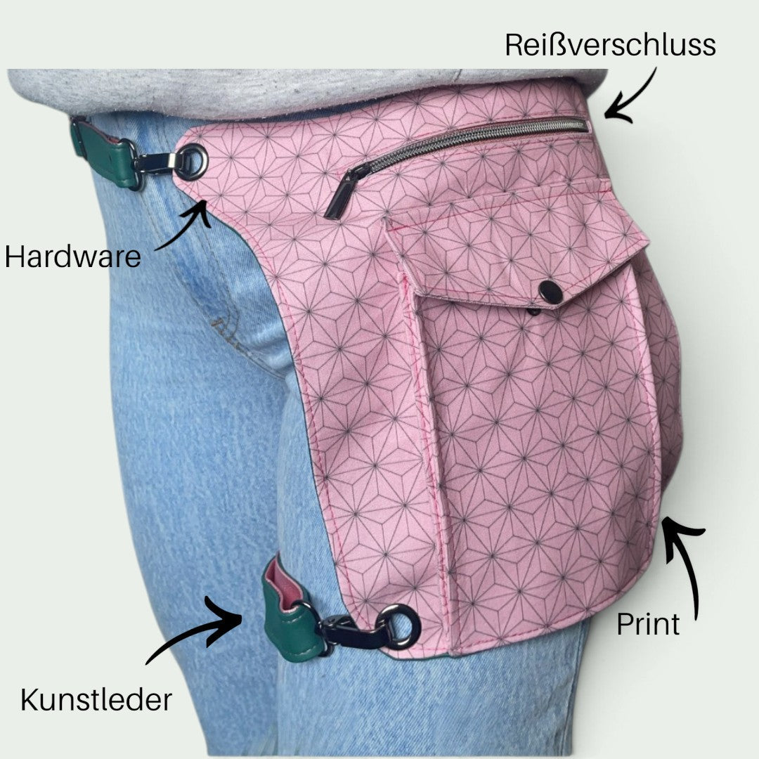 Schneckenschmiede Whippersnapper Hüfttasche in Rosa mit geometrischem Muster, getragen am Oberschenkel über Jeans.