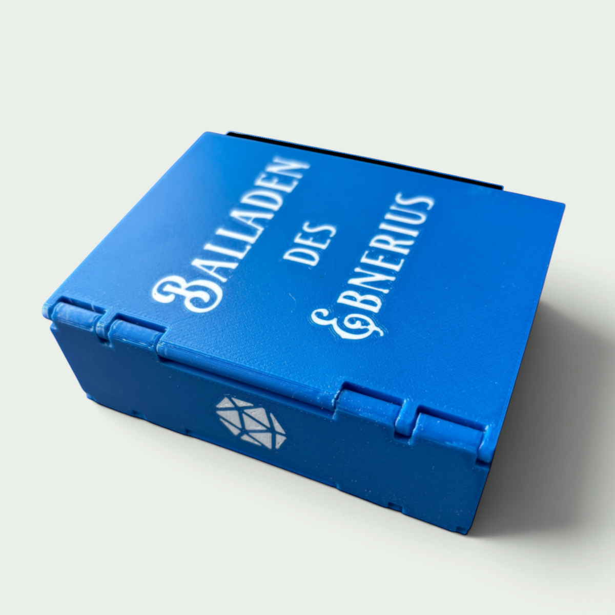 Schneckenschmiede Würfelbuch in Blau mit personalisiertem Schriftzug und Würfelsymbol als Transportbox für Pen and Paper